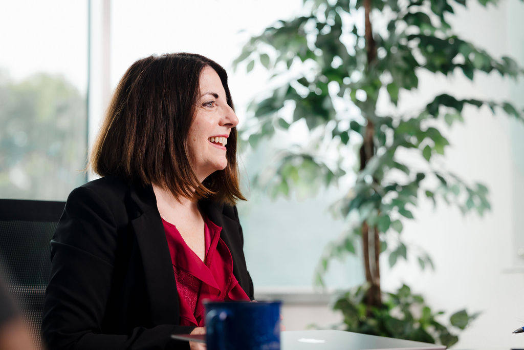 UltraOptics-CustomerService-Employee An Ultra Optics employee sits at a conference table and talks with a customer